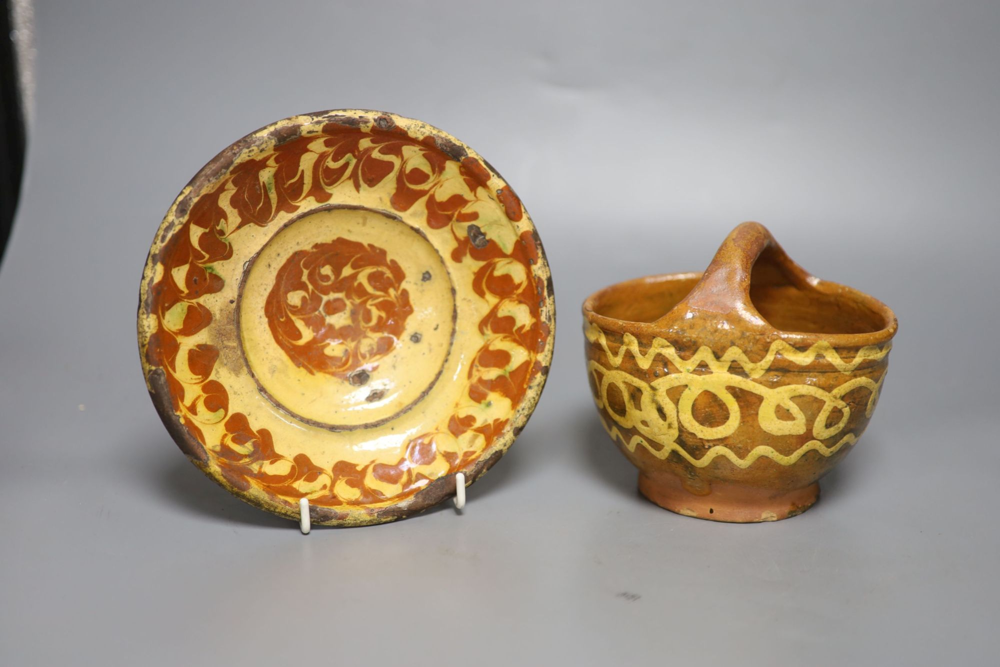 An early 19th century slipware basket, Donyatt Somerset and a similar slipware dish, diameter 18cm